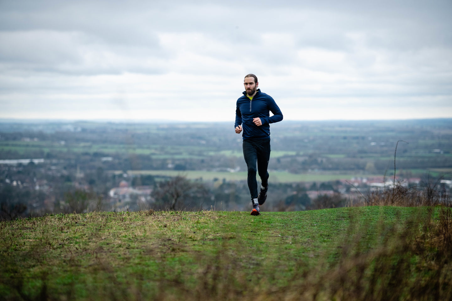 Man running up a grassy hill