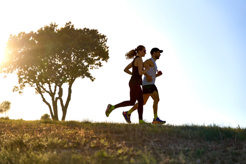 Two runners on a hillside at golden hour