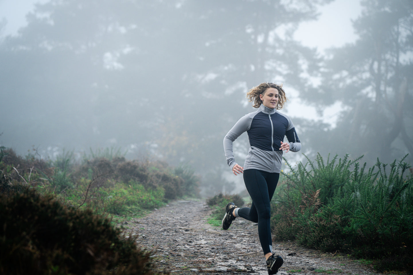 Woman running on a foggy path in nature