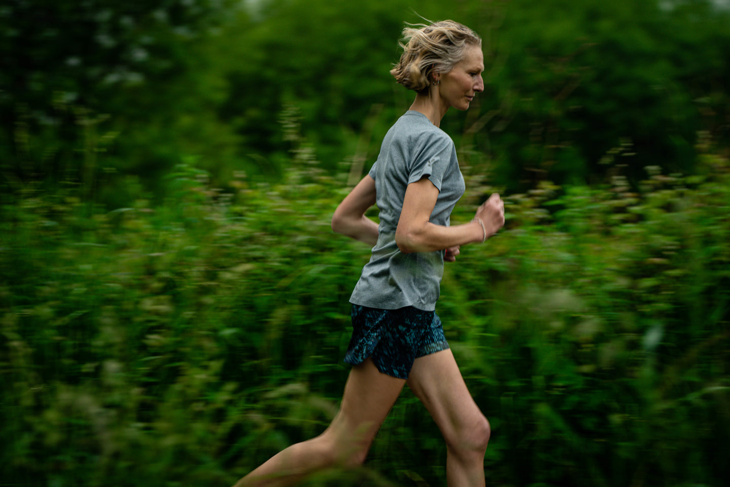 Woman running through a green forest